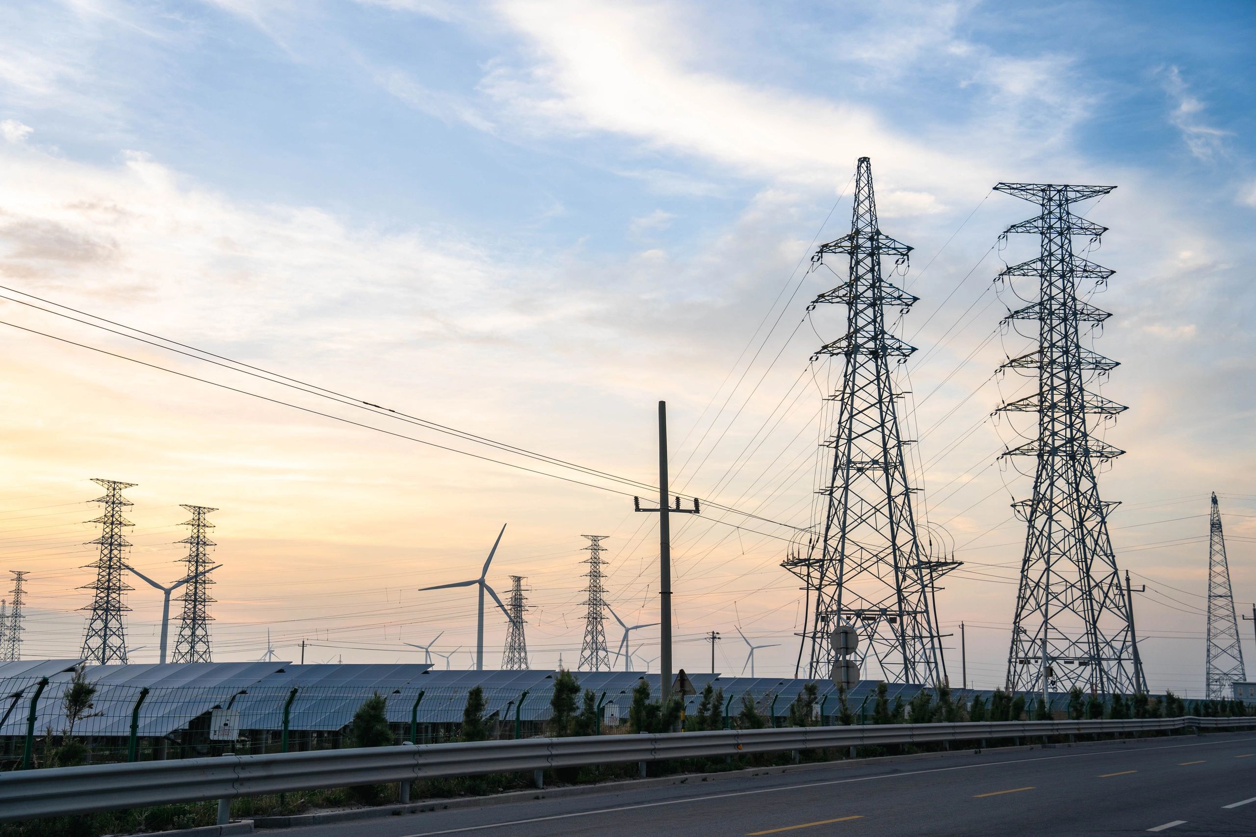 Renewable energy park with transmission infrastructure at dusk